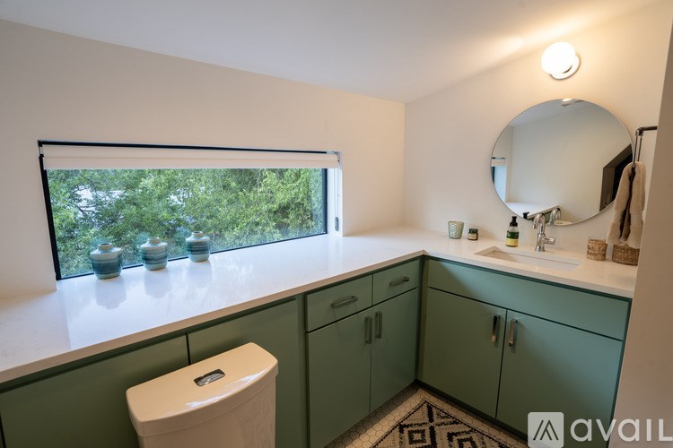 A bathroom with green cabinets and a white toilet.