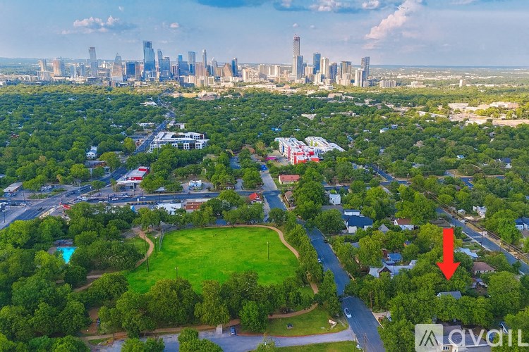 An aerial view of a city with a red arrow pointing to a specific area.