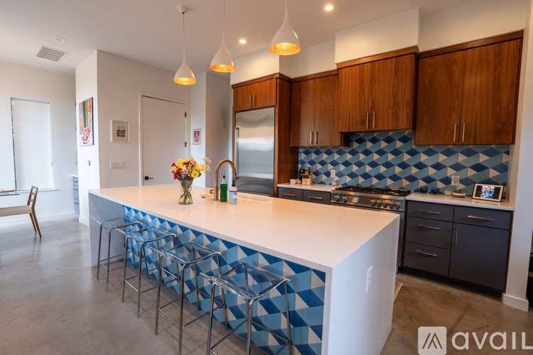 A kitchen with a white countertop and blue tiled backsplash.