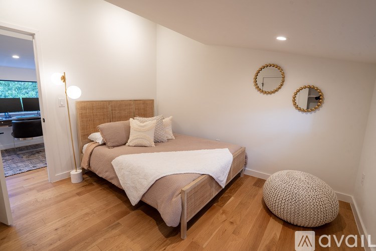 A bedroom with a large bed and two round mirrors on the wall.
