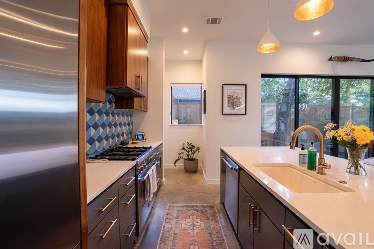 A kitchen with a stainless steel refrigerator and wooden cabinets.