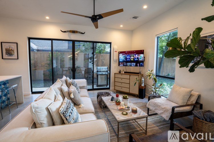 A living room with a white couch and a ceiling fan.