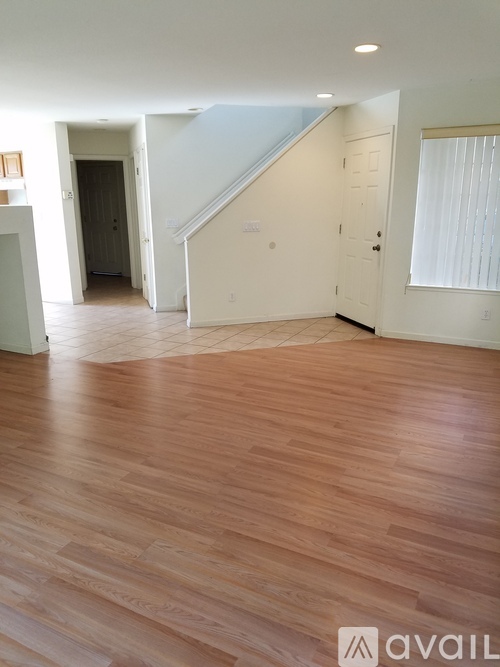 A room with wooden flooring and a staircase.