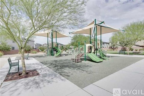 A playground with a green slide and a canopy.
