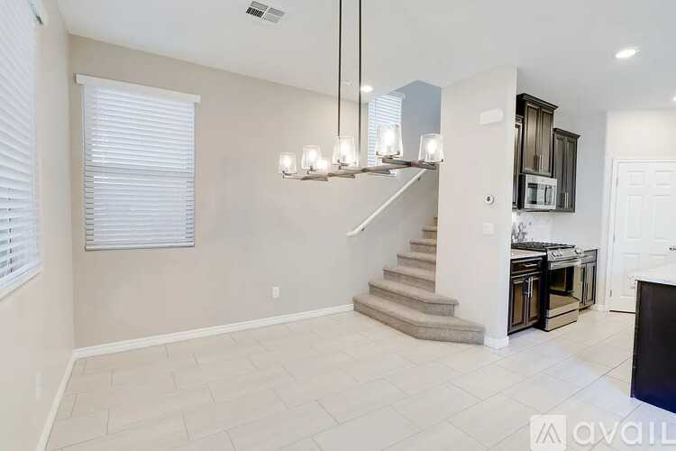 A spacious living room with a staircase leading to the upper floor.