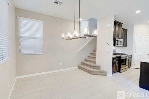 A spacious living room with a staircase leading to the upper floor.