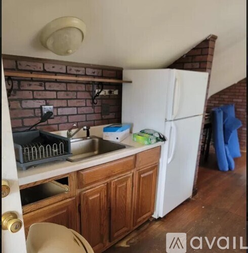 A kitchen with a white fridge and wooden cabinets.