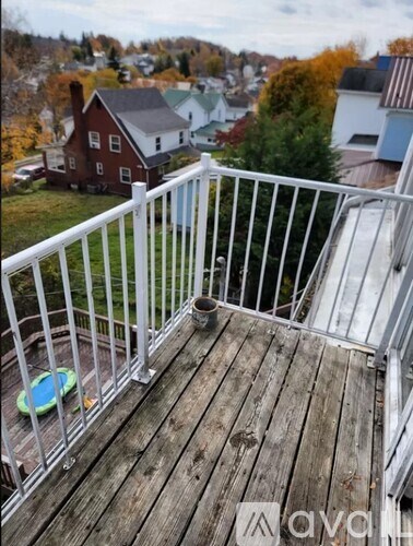 A deck with a white railing and a green pool toy.