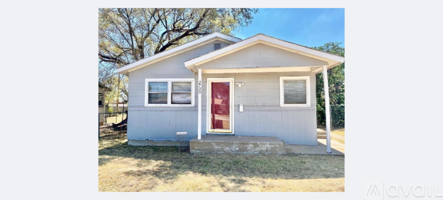 A small white house with a red door is for lease.