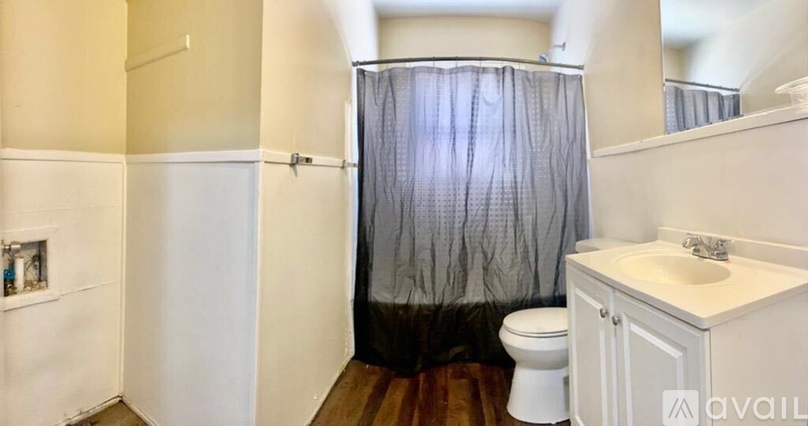 A bathroom with a toilet, sink, and shower curtain.