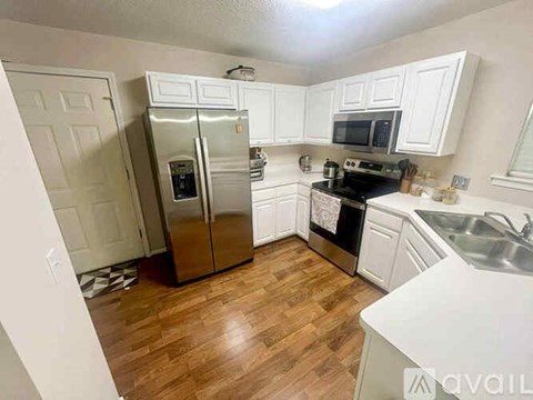 A kitchen with a refrigerator, stove, and microwave.