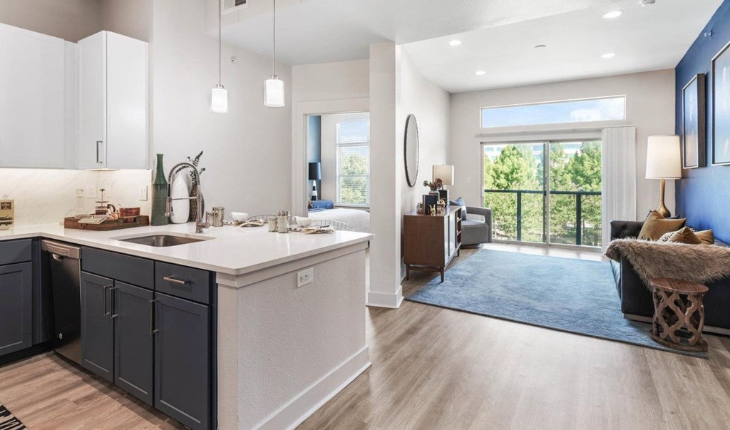 A modern kitchen with dark grey cabinets and a white countertop.