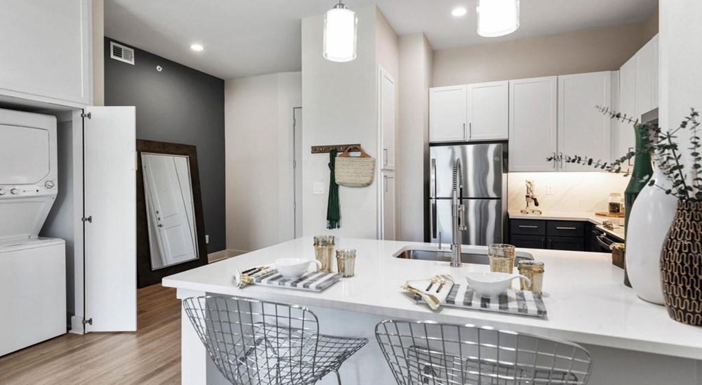 A modern kitchen with white cabinets and a white island.