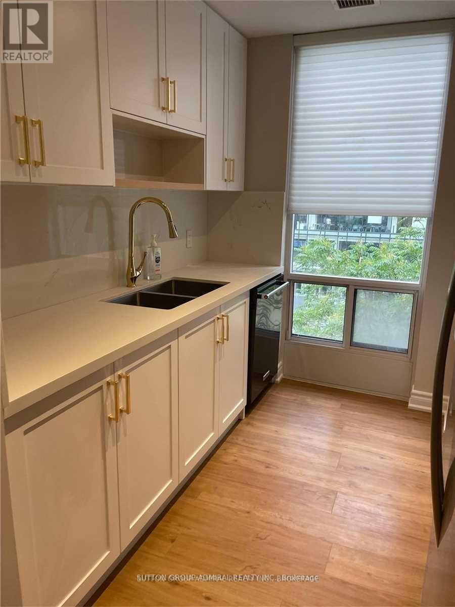 A kitchen with white cabinets and a sink.