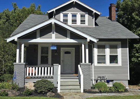 A house with a grey front porch and a white door.