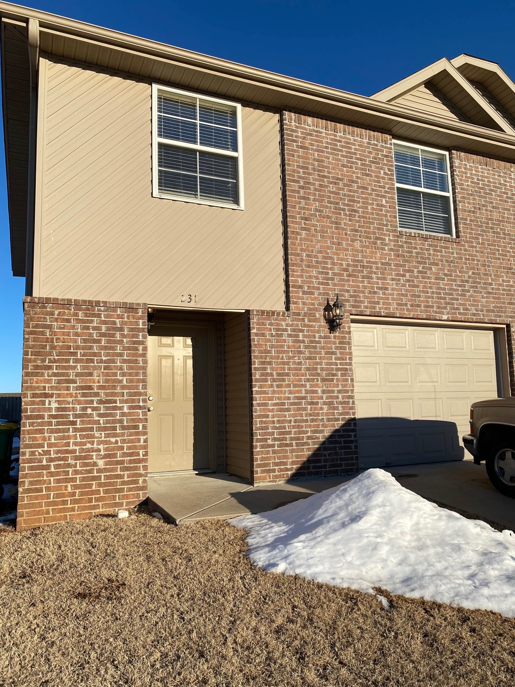 A house with a brown brick facade and a tan garage door.