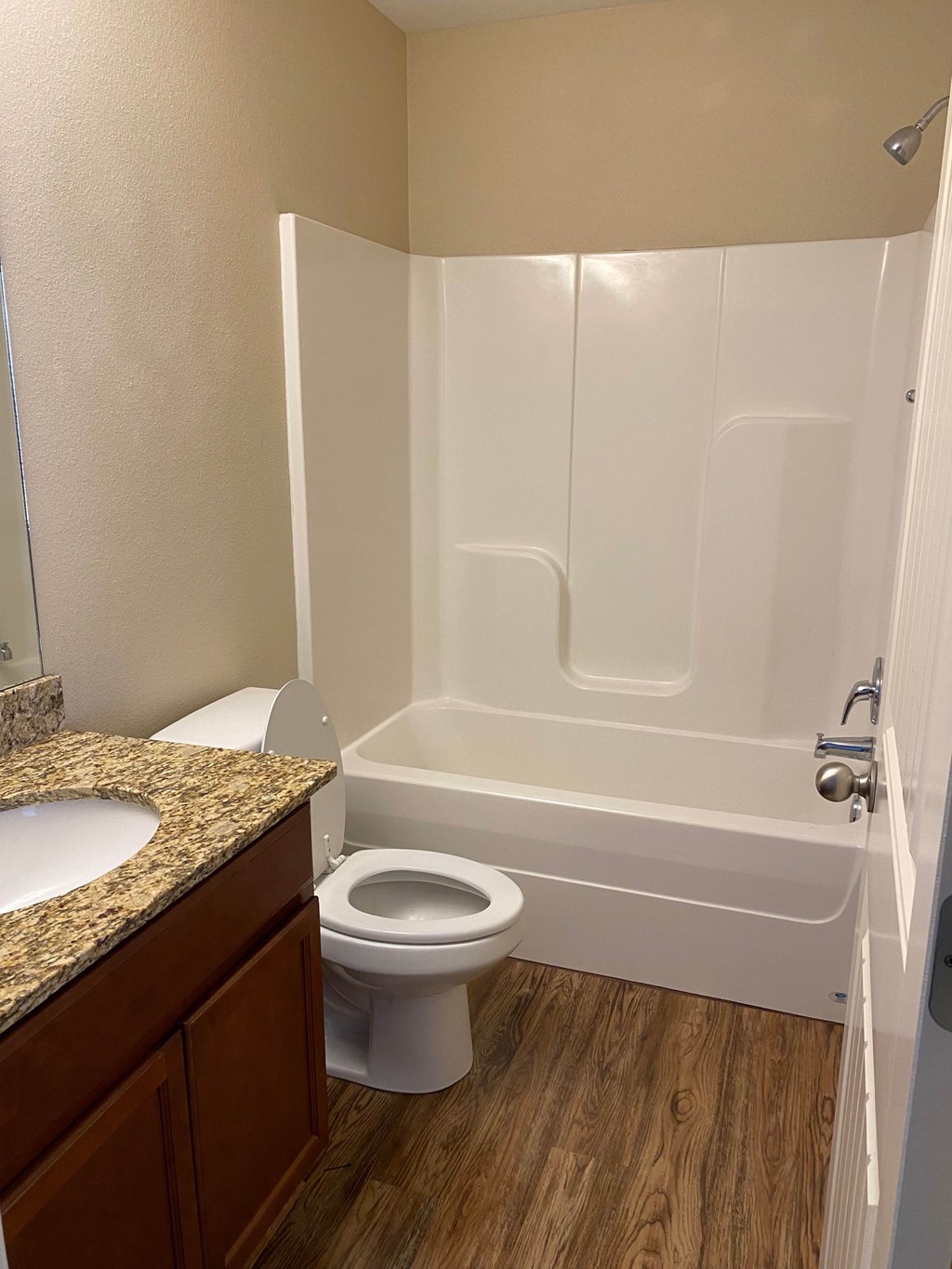 A white toilet sits next to a bathtub in a bathroom.