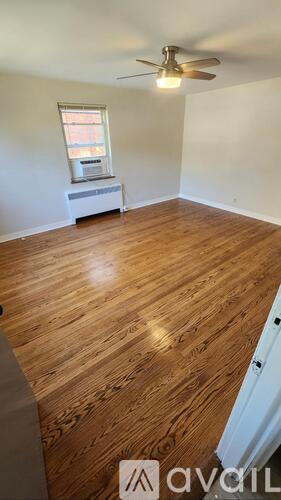 A room with wooden flooring and a ceiling fan.