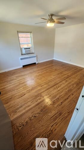 A room with wooden flooring and a ceiling fan.