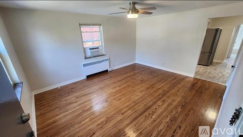 A room with wooden flooring and a ceiling fan.