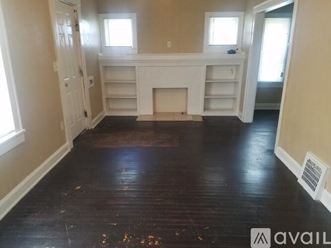 A room with a fireplace and a wooden floor.