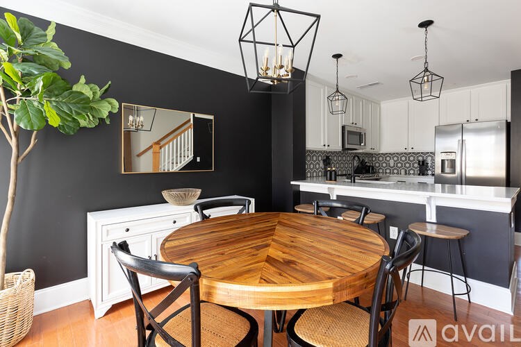 A modern kitchen with a wooden table and chairs.