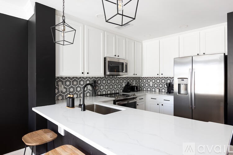 A modern kitchen with a white countertop and black cabinets.