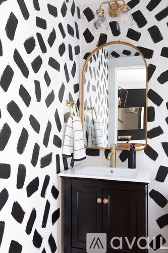 A bathroom with a black and white patterned wall.