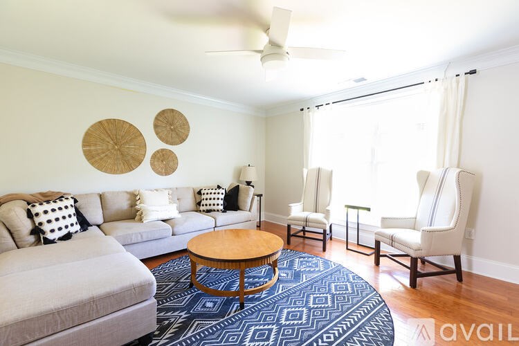 A living room with a grey couch, a wooden coffee table, and a fan on the ceiling.