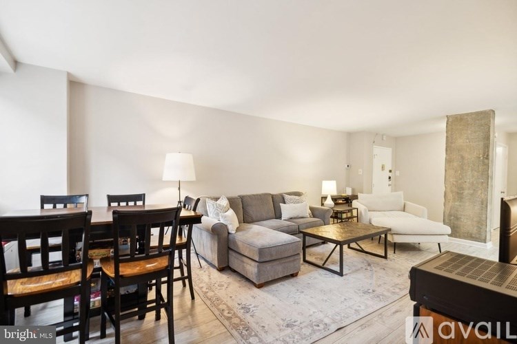A living room with a grey couch, a coffee table, and a lamp.