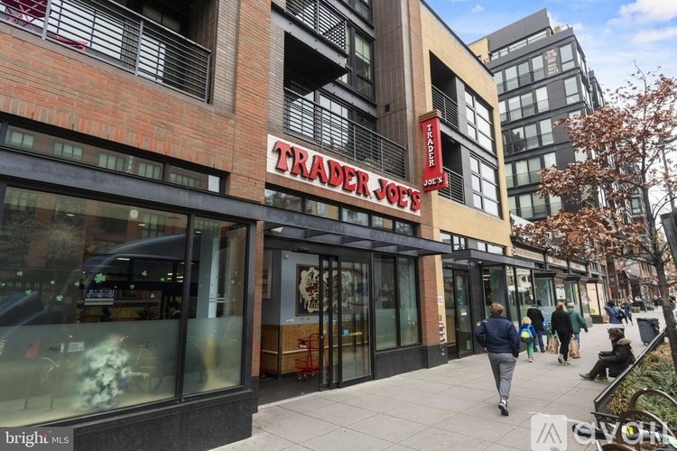 A man is walking past a building with a red sign that says "Transfer Joe's".