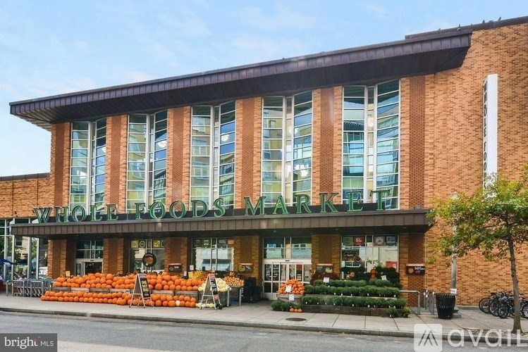 A Whole Foods Market store with a display of oranges in front.