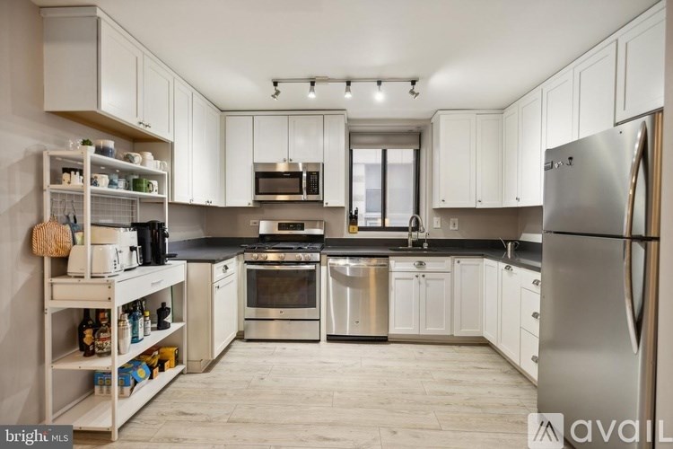 A kitchen with white cabinets and stainless steel appliances.