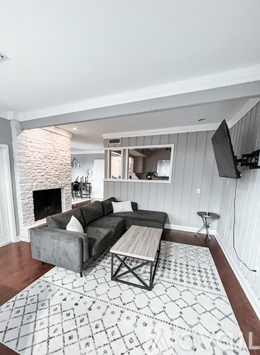 A living room with a grey couch and a patterned rug.