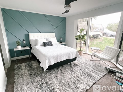 A bedroom with a white bed and a ceiling fan.