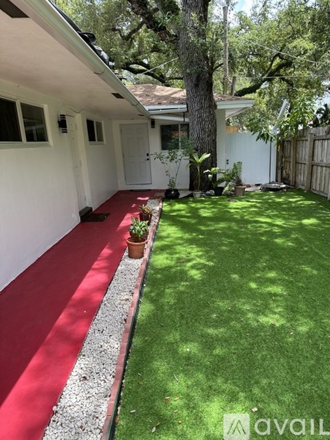A white house with a red carpet and a green lawn.