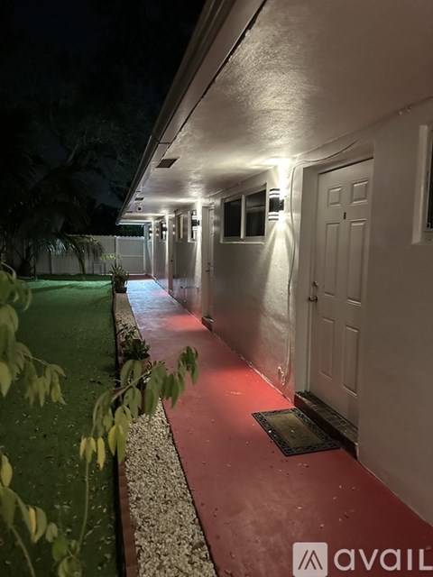 A long hallway with lights on the wall and doors on the side.