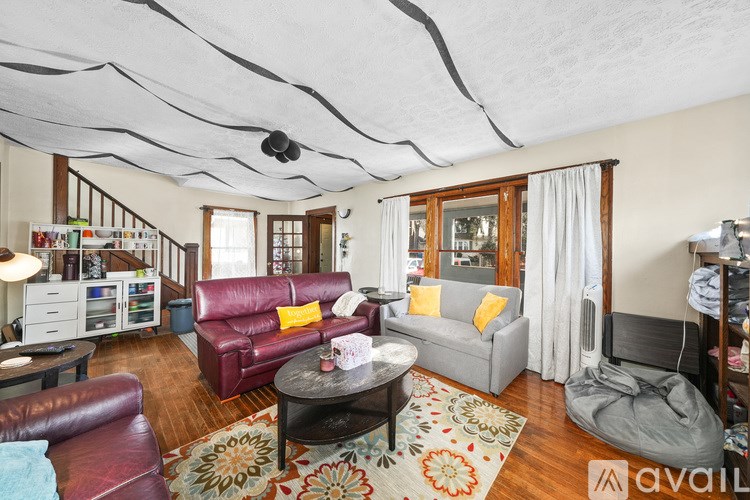 A living room with a red couch and a grey couch, a coffee table, and a rug.