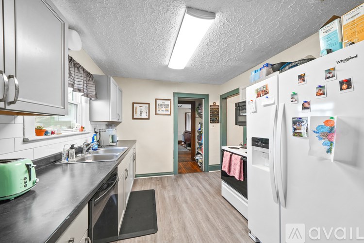 A kitchen with a white fridge covered in magnets.