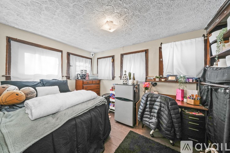 A bedroom with two beds, a desk, and a chair.