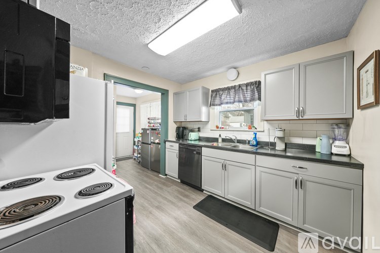 A kitchen with a stove top oven and a sink.