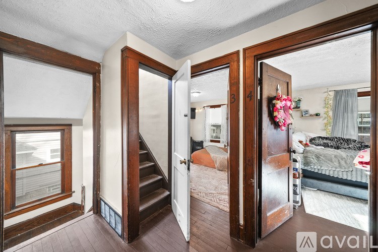 A bedroom with a bed, a window, and a staircase.