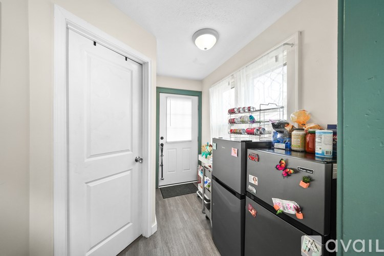 A kitchen with a black fridge and a white door.