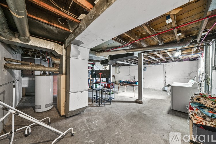 A large, empty room with a lot of unfinished work and a lot of pipes.