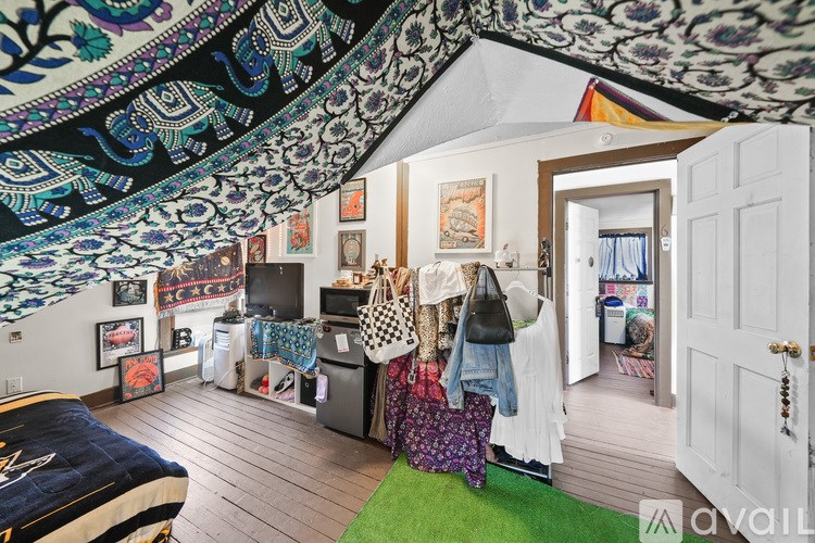 A room with a bed and a wall hanging with a pattern on it.