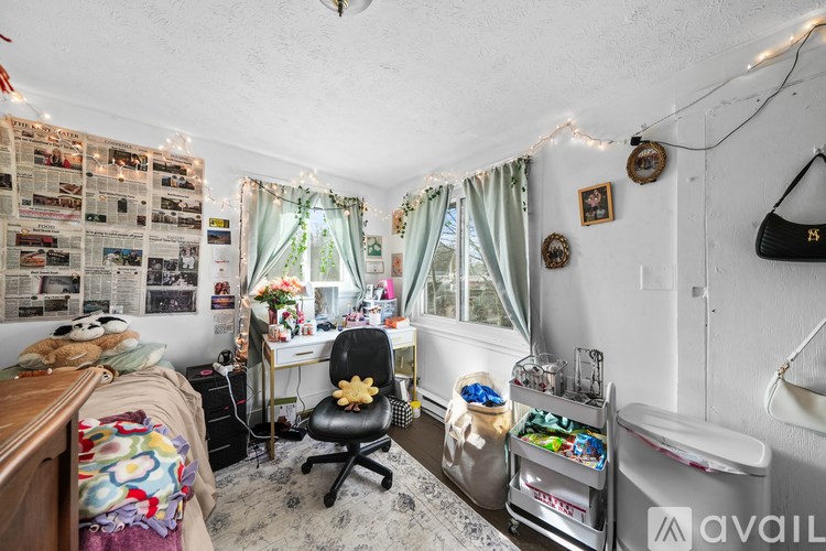 A room with a desk, chair, and a wall covered in newspaper clippings.