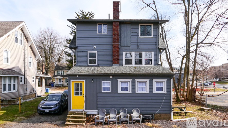 A house with a grey exterior and a yellow door.