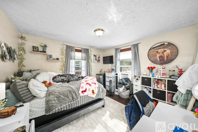 A bedroom with a bed, a desk, and a chair.