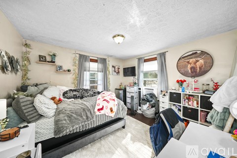 A bedroom with a bed, a desk, and a chair.