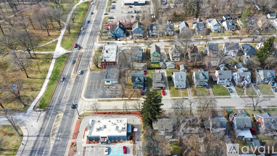 A suburban street with houses on both sides and a small business in the middle.